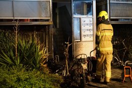 Scooters in brand bij portiek flat in Den Helder
