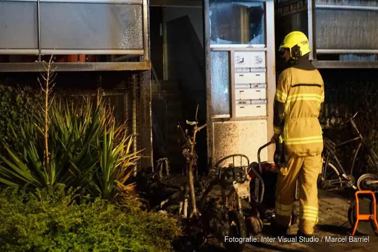 Scooters in brand bij portiek flat in Den Helder