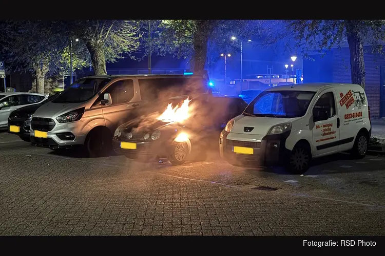Auto in brand op parkeerplaats achter hotel
