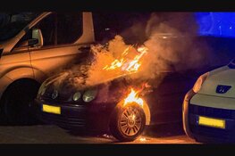 Auto in brand op parkeerplaats achter hotel