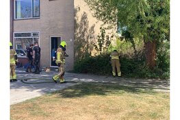 Brand in bosschage naast woningen in Den Helder, brandweer voorkomt overslag