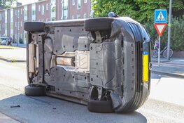 Auto op z'n kant na ongeval op Middenweg