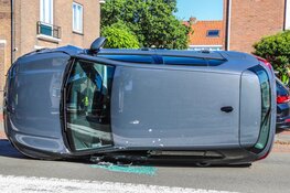 Auto op z'n kant na ongeval op Middenweg