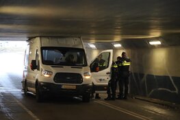 Bestelbus gevuld met pakketjes rijdt zich klem onder viaduct