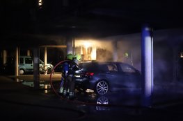 Auto in brand achter woningen in Den Helder