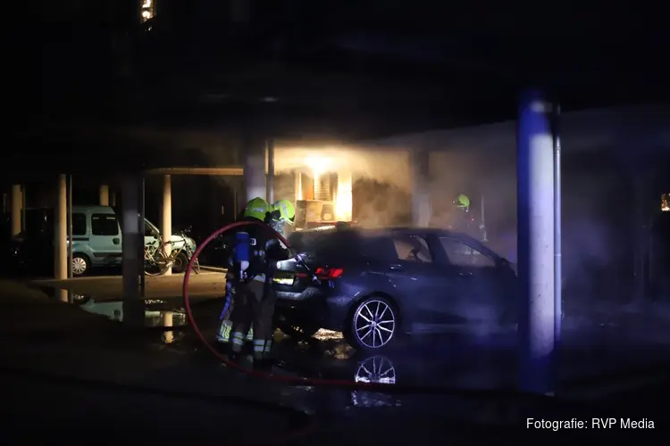 Auto in brand achter woningen in Den Helder