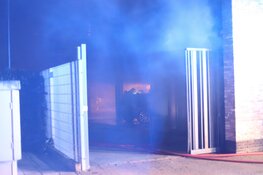 Auto in brand achter woningen in Den Helder
