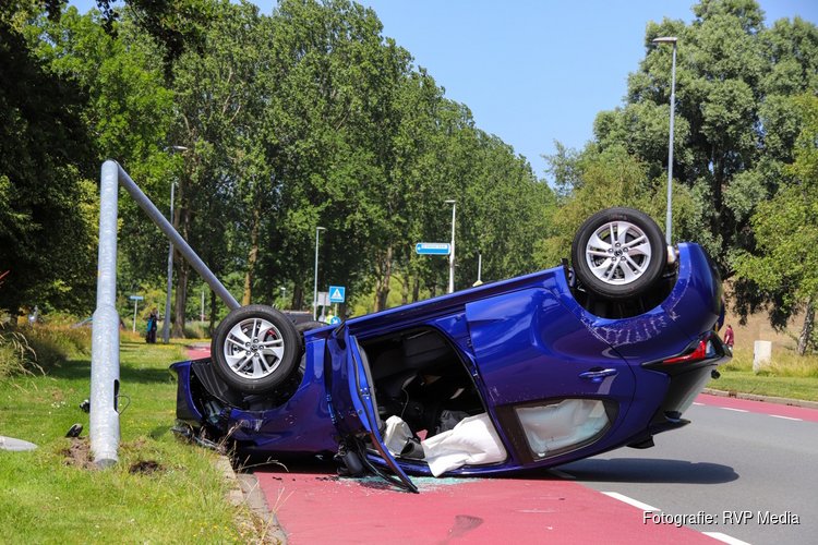 Hagelnieuwe auto vliegt over de kop na botsing tegen lantaarnpaal in Den Helder