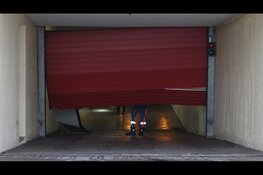 Auto rijdt dwars door roldeur van ondergrondse parkeergarage in Den Helder