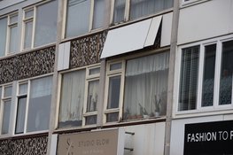 Gevelpanelen waaien los van pand in Den Helder door harde wind